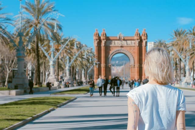 Barcelona, Spain: woman standing on road near concrete arch de Triomf at daytime