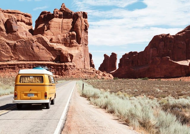 yellow volkswagen van on road to summer camp