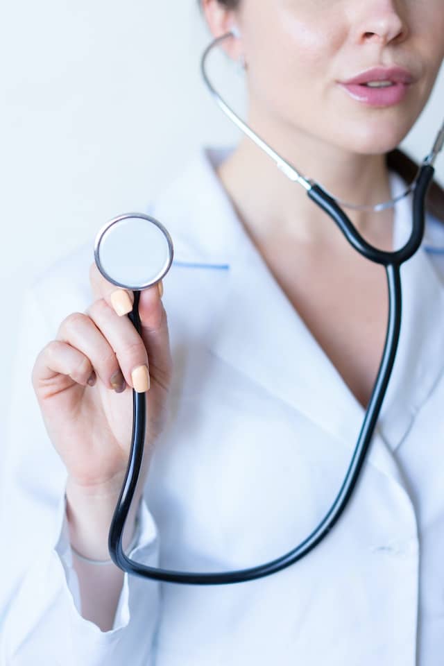 A Travel Medical Assistant in a white shirt holding a stethoscope